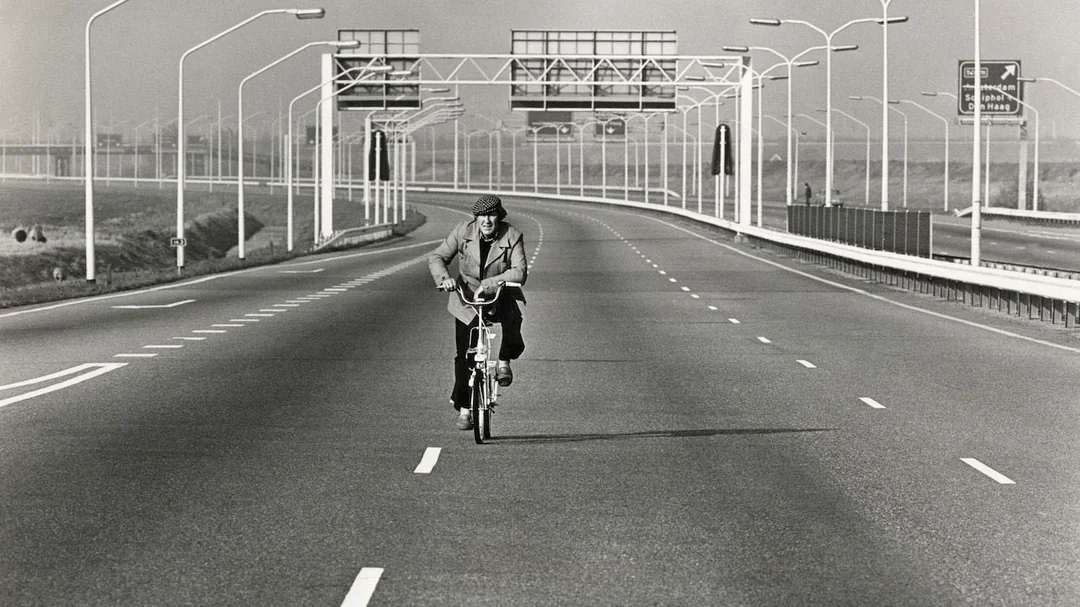 Mężczyzna jedzie rowerem pustą autostradą w Holandii podczas niedzielnego zakazu jazdy samochodem w czasie kryzysu naftowego 1973 roku